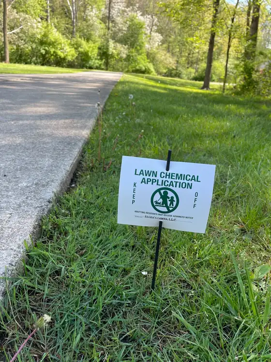 Elora's Lawns lawn application sign posted beside a driveway